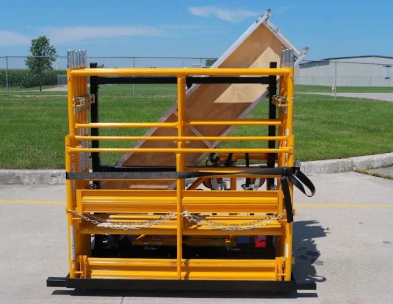 Portable yellow scaffolding system with wooden platform on jobsite